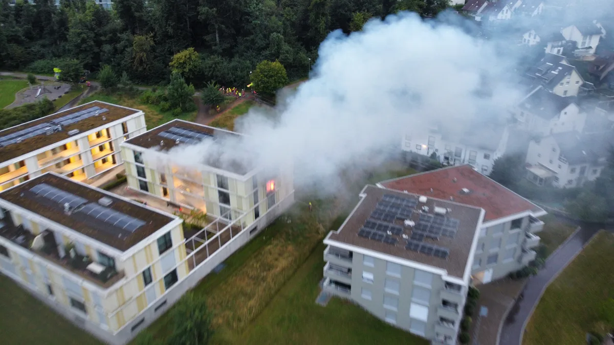 Rauch steigt aus einem Mehrfamilienhaus.